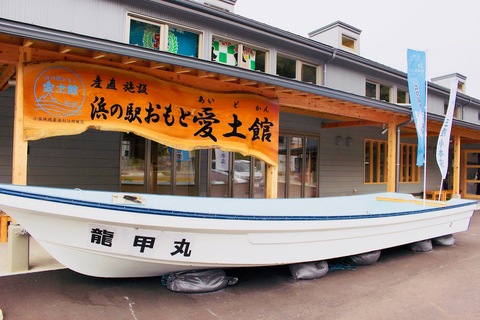 看板の前に「龍甲丸」という船が飾られている。