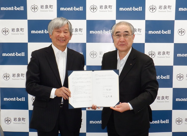 協定書を掲げる辰野勇代表取締役会長（左）と中居健一岩泉町長（右）
